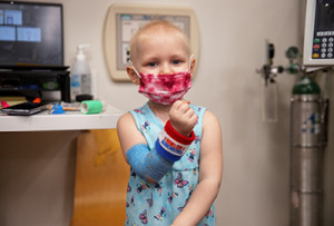 Luna McClanahan, a three-year-old patient with leukemia, shows off her new wristband given to her by Harlem Globetrotters, “Crash” and “Too Tall,” during their visit to the children’s hospital on Wednesday, March 27, 2024.